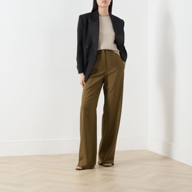 Model wearing Max Mara Main Ginseng Knitted Vest in Stone, styled with olive wide-leg trousers and a black blazer