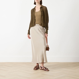 Model wearing Max Mara Main kaki knit cardigan and top, styled with beige satin midi skirt and brown leather sandals.