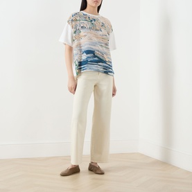 Model wearing Max Mara Weekend Terzo Silk Waterscape T-Shirt in light blue with cream wide-leg trousers and brown loafers
