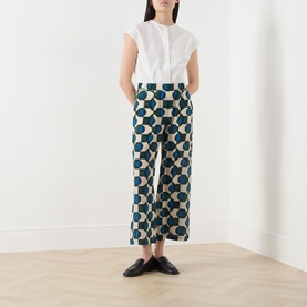 Model wearing Max Mara Weekend Eusebio Silk Printed Trousers in dark green geometric print, cropped wide-leg, styled with white sleeveless top and