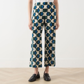 Model wearing Max Mara Weekend Eusebio Silk Printed Trousers in dark green geometric print, cropped wide-leg fit, styled with black loafers