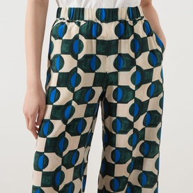 Model wearing Max Mara Weekend Eusebio Silk Printed Trousers in dark green geometric print, high-rise wide-leg cropped style with elasticated waist