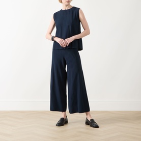 Model wearing Max Mara Weekend navy wide-leg pleated trousers, styled with matching sleeveless top and black loafers.