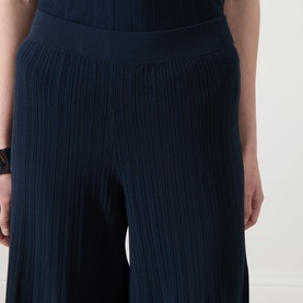 Model wearing Max Mara Weekend navy ribbed wide-leg trousers with elasticated waist, styled with matching navy top.