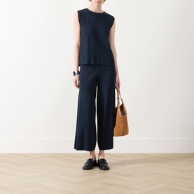 Model wearing Max Mara Weekend navy wide-leg ribbed trousers, styled with matching ribbed top, loafers and tan bucket bag.