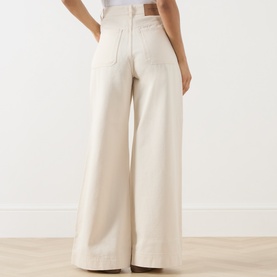 Model wearing Max Mara Weekend ecru wide-leg cotton trousers, rear view, styled with a white top.