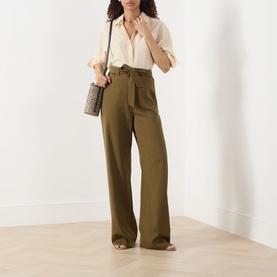 Model wearing Max Mara Main Editto Wide-Leg Trousers in kaki, high-rise, full length, styled with a black blazer and beige top.