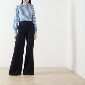 Model wearing Max Mara Main ultramarine wide-leg cotton trousers, styled with a blue striped shirt.