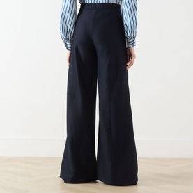 Model wearing Max Mara Main ultramarine wide-leg cotton trousers, styled with a blue striped blouse, rear view