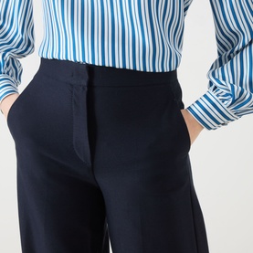 Model wearing Max Mara Main ultramarine cotton trousers with a high waist and straight leg, styled with a blue striped shirt.