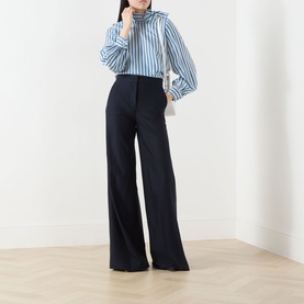 Model wearing Max Mara Main ultramarine wide-leg cotton trousers, styled with a blue striped shirt.