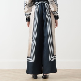 Model wearing Max Mara Main Carabo Printed Wide Leg Trousers in ultramarine, wide-cut silk-twill with geometric stripe print, styled with matching