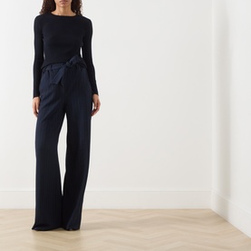 Model wearing Max Mara Lira Striped Wide Leg Trousers in ultramarine with tie waist belt, styled with a navy long-sleeve top.