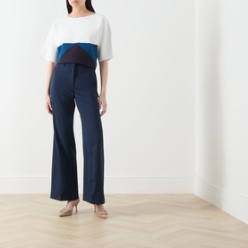 Model wearing Max Mara Weekend navy wool wide-leg trousers, styled with a colour-block top and nude heels.