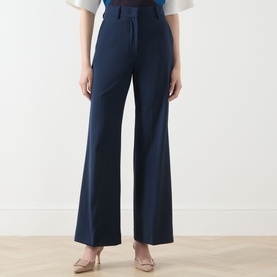 Model wearing Max Mara Weekend navy wide-leg wool trousers with belt loops, styled with nude heeled mules