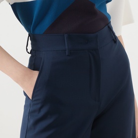 Model wearing Max Mara Weekend navy wool trousers, close-up of high-waisted fit with belt loop detail, styled with teal top.