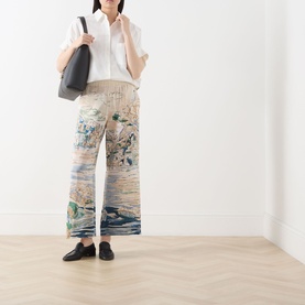 Model wearing Max Mara Weekend light blue abstract-print silk trousers, styled with white shirt, black tote bag and loafers