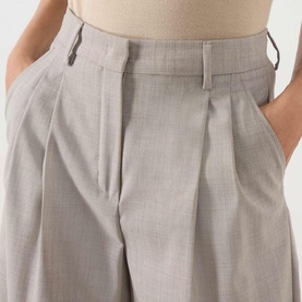 Model wearing Max Mara Weekend hazelnut wide-leg wool trousers with double pleats, high waist, and belt loops, hands in pockets