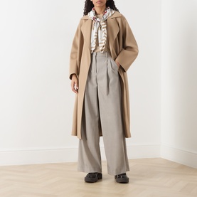Model wearing Max Mara Weekend Hazelnut wool trousers with a camel longline coat and striped scarf, styled with black chunky loafers.