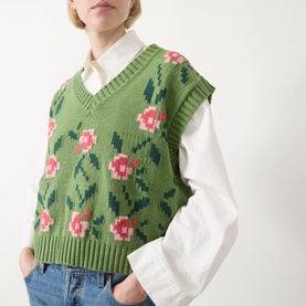 Model wearing Max Mara Weekend Alamaro Floral Knit Vest in Green Floral with pink rose intarsia, styled over a white shirt with blue jeans.