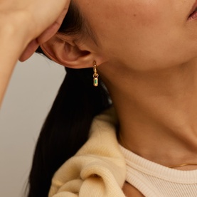 Model with Missoma Gold Olive drop earrings featuring small rectangular charm pendant on gold hook fitting