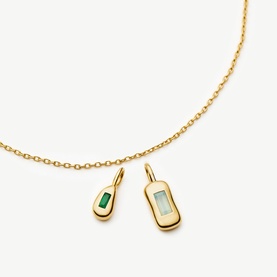 Missoma gold chain necklace with two charm pendants: a green baguette stone drop and a pale blue rectangular stone in gold settings
