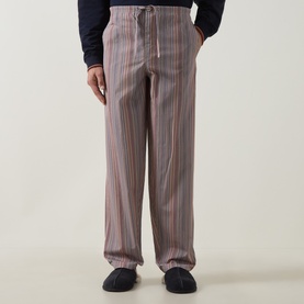 Model wearing Paul Smith Access multicolour striped cotton pyjama bottoms with drawstring waist, styled with dark slippers.