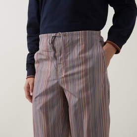 Model wearing Paul Smith Access multicolour striped cotton pyjama bottoms with elasticated drawstring waist, styled with navy top.