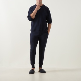 Model wearing Paul Smith Access blue cotton loungewear top with matching navy joggers and dark slippers.