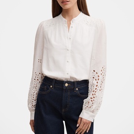 Model wearing Forever New Sutton Embroidered Blouse in Porcelain with broderie sleeves and stand neckline, styled with dark blue jeans