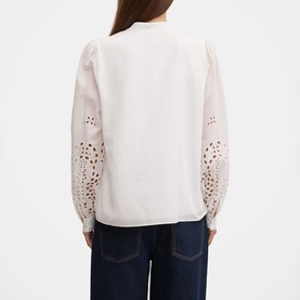 Model wearing Forever New Sutton Embroidered Blouse in Porcelain with broderie anglaise sleeves and scalloped trim, styled with dark denim jeans