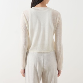Model wearing AMERICAN VINTAGE Epaky Fine-Knit Cropped Cardigan in Ecru, back view, styled with light grey wide-leg trousers.