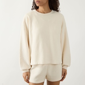 Model wearing American Vintage Bobypark Textured Sweatshirt in ecru, styled with matching shorts. Round neck, dropped shoulders, long sleeves.