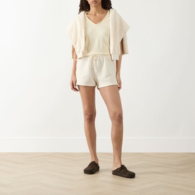 Model wearing American Vintage Sonoma T-Shirt in Vanille Vintage, styled with matching cream shorts and dark slip-on shoes