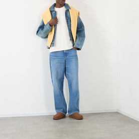 Model wearing About:Blank Oblique Logo T-Shirt in oat, styled with colour-block denim jacket, light-wash jeans and tan suede mules.