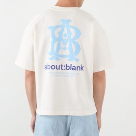 Model wearing About:Blank oat T-shirt, rear view showing blue and navy branded monogram and logo graphic print.