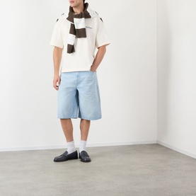 Model wearing About:Blank oat cotton T-shirt with light blue denim shorts, brown scarf, white socks and black loafers.