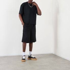 Model wearing About:Blank Raw Hem Ellipse T-Shirt in washed black with matching shorts, white socks and black platform trainers.