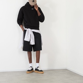 Model wearing About:Blank Arc Logo Hoodie in black with matching shorts, white shirt tied at waist, white socks and gum-sole trainers.