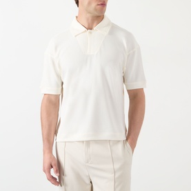 Model wearing cream short-sleeve polo shirt with zip collar, styled with light beige tailored trousers