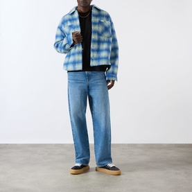 Model wearing About:Blank Box Logo T-Shirt in black, styled with blue check overshirt, light wash jeans and navy canvas shoes.