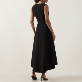 Model wearing Anne Louise Boutique black sleeveless midi dress with asymmetric hem, viewed from the back.