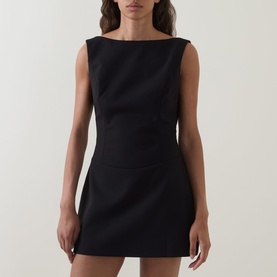 Model wearing Anne Louise Boutique Tailored Mini Shift Dress in black with boat neckline, sleeveless cut and flared mini skirt