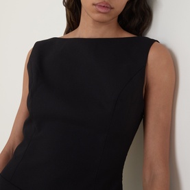 Model wearing Anne Louise Boutique Tailored Mini Shift Dress in black, showing boat neckline and sleeveless silhouette
