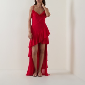 Model wearing Anne Louise Boutique Rose Petal Ruffle Dress in red, V-neckline, tiered ruffle skirt, asymmetric high-low hem, styled with strappy heels