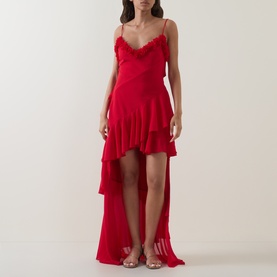 Model wearing Anne Louise Boutique Rose Petal Ruffle Dress in red with tiered ruffle skirt, high-low hem, and lace trim neckline. Styled with clear