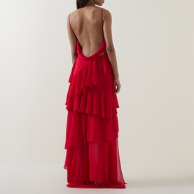 Model wearing Anne Louise Boutique Rose Petal Ruffle Dress in red, showing low-cut cowl back, narrow straps, and tiered ruffle maxi skirt