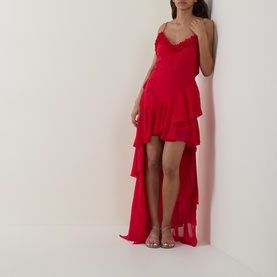 Model wearing Anne Louise Boutique Rose Petal Ruffle Dress in red, featuring V-neckline, lace trim, tiered ruffle high-low skirt, styled with strappy