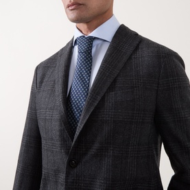 Model wearing Boglioli charcoal wool check jacket, styled with a light blue shirt and navy dotted tie.