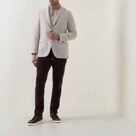 Model wearing Boglioli beige wool-blend jacket, styled with brown trousers and dark trainers.